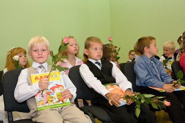 koolilapsed istuvad aabitsate ja lilledega