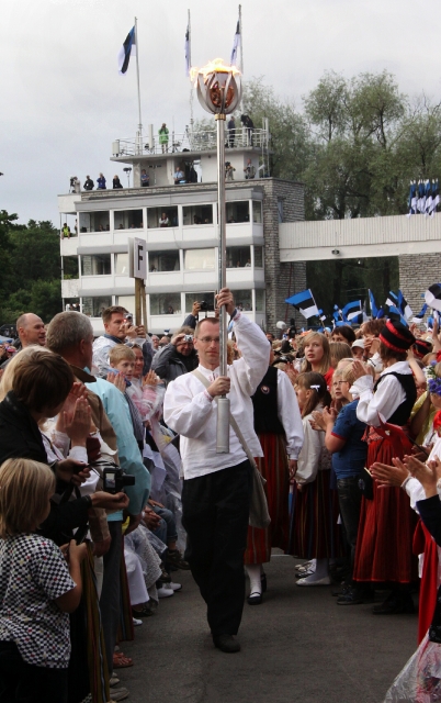 TULE TULEMINE: Ants Liigus on talletanud fotodele selle, kuidas Kambja koori liige Margus Kriiva viib tuhandete lauljate, peoliste ja televaatajate pilkudest saadetuna tuletorni tippu peotuletõrviku, mille laululava ees andis talle üle meie rahvusliku koorimuusika suurkuju Veljo Tormis. laulupeotule kandmine tõrvikuga