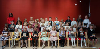 Muusikakoolis Õpilased istumas saalis ühispildil, tagareas seisab õpetaja