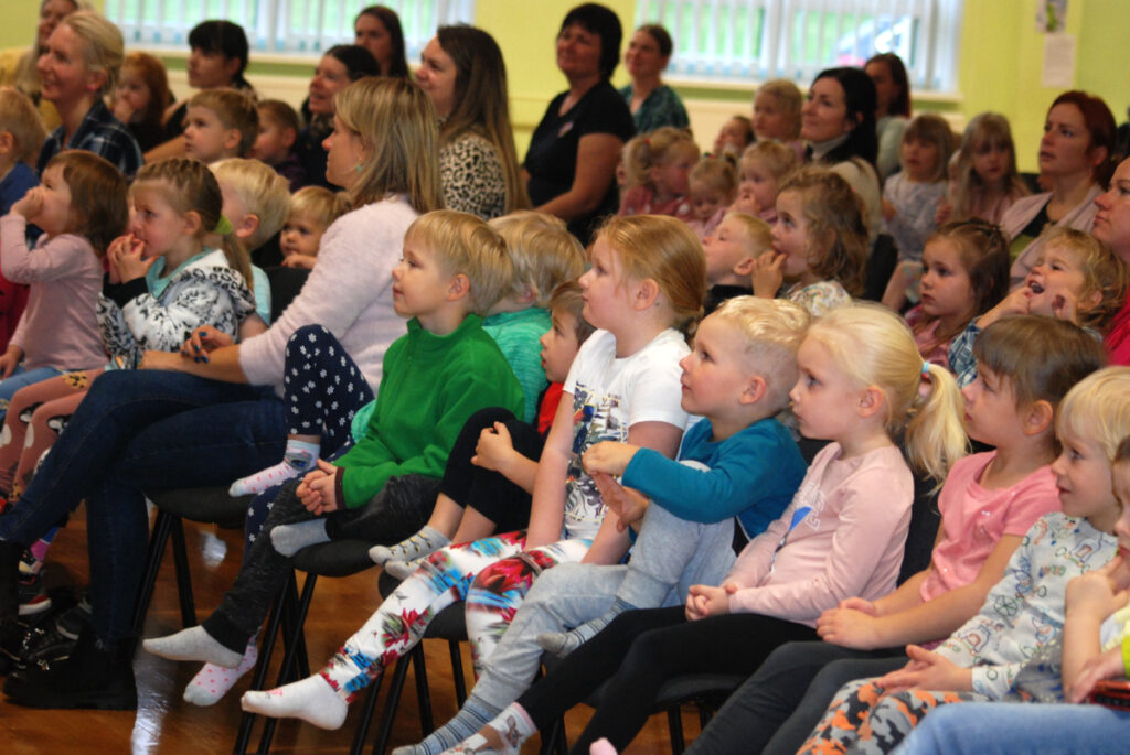 Lasteaialapsed kontserti jälgimas saaliistmetel istudes.