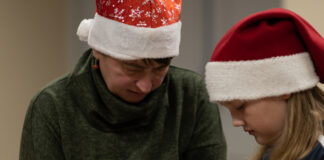 Taaskohtumine jõuluootuse ajal Päkapiku mütsiga naine ja neiu.