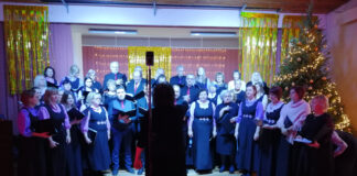 Kambja segakoor Läte toimekas detsember Koor esinemas, dirigent juhatamas, jõulukuusk saali nurgas.