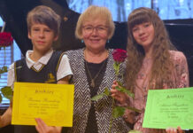 Muusikakoolis õpetaja keskel, õpilased diplomitega küljel