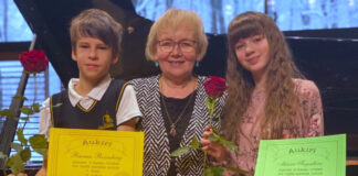 Muusikakoolis õpetaja keskel, õpilased diplomitega küljel