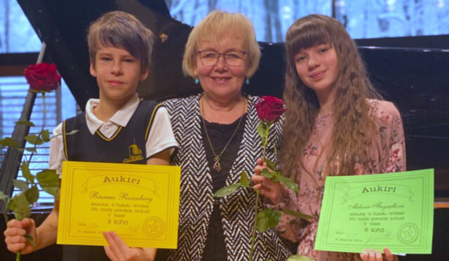 õpetaja keskel, õpilased diplomitega küljel