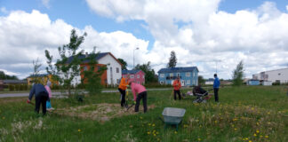 Vilgas külaelu toob inimesed aina rohkem külaplatsile kokku Inimesed labitadega liivakasti korrastamas, taamal lapsevanker, ealmud.