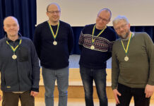 Tartumaa talimängude mälumängu II koht Medaleid kandev meeskond rõõmsalt poseerimas.