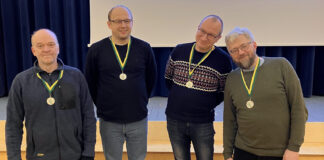 Tartumaa talimängude mälumängu II koht Medaleid kandev meeskond rõõmsalt poseerimas.