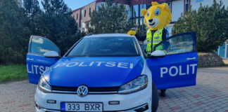 Liiklushommik politseiga Linnaverel Lõvikostüümis politseinik politseiautoga.