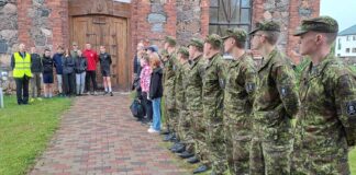 Jooksjad - õpilased ja sõdurid riivstunud kiriku külgkäigul.