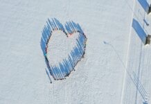 Teeme Eesti Suurima Südame Kambjas Droonifoto lumisel väljakul seisvatest inimestest, kes moodustavad südamekuju