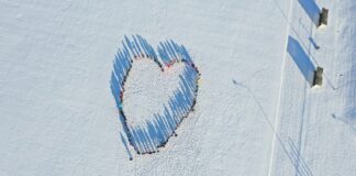 Teeme Eesti Suurima Südame Kambjas Droonifoto lumisel väljakul seisvatest inimestest, kes moodustavad südamekuju