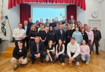 Vana-Kuuste mõisakoolis pandi alus uuele traditsioonile Koolisaalis tehtud grupifotol poseerib suur hulk eri vanuses inimesi – õpilased, õpetajad ja kogukonna liikmed. Esireas istuvad noored, nende taga seisavad täiskasvanud. Taustal on lava punaste kardinate ja projektoriekraaniga, millel on kiri „Kogukonnapäev Kuuste koolis“. Saali seinal on kell ning vasakul pool seisab lipp. Õhkkond on pigem sõbralik, viidates ühisele sündmusele ja kogukonna koostööle.